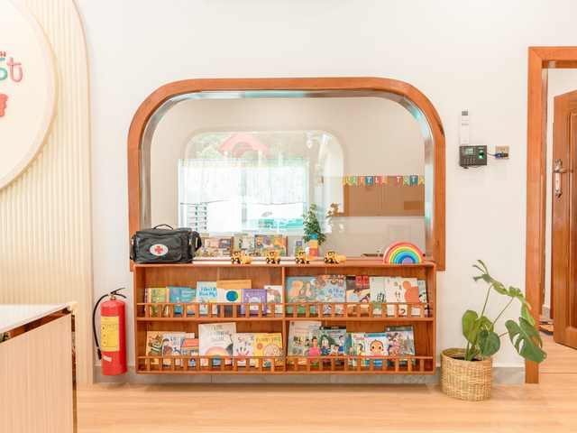 Open wooden shelving holding books and learning materials at Orange Crest Preschool