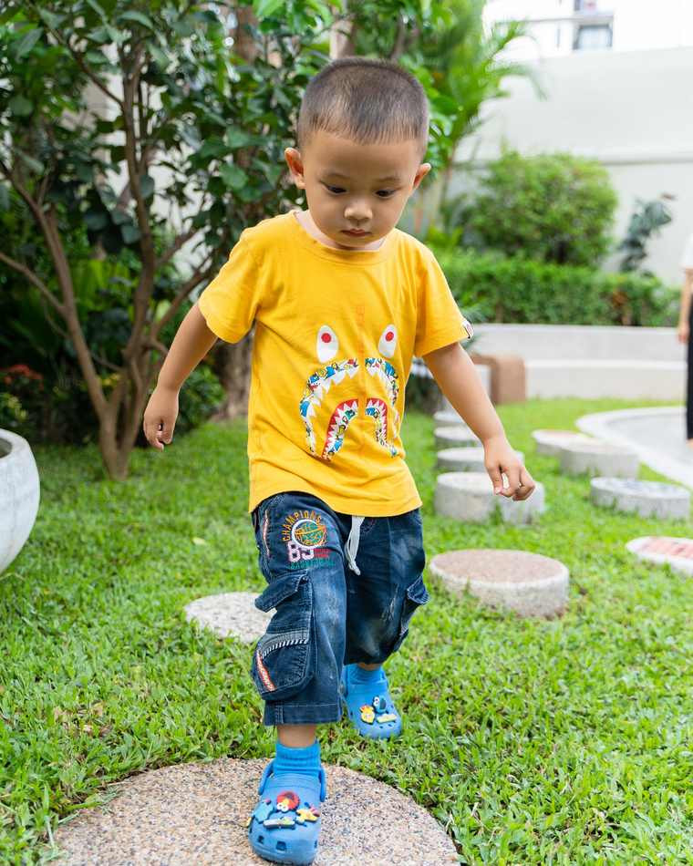 A child crossing the stepping stones in the garden at Orange Crest Preschool