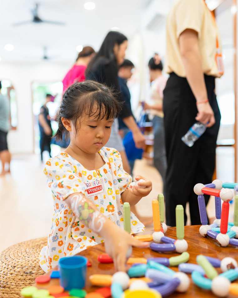 A child at Orange Crest Preschool playing with natural wooden toys