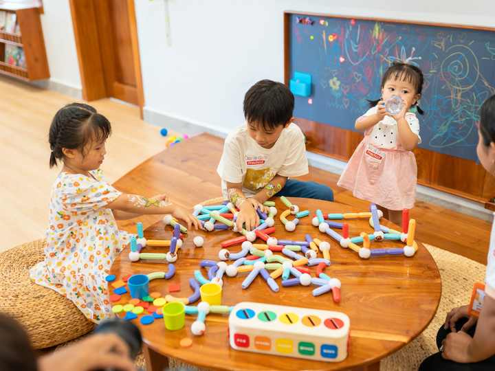 Children working together around a low activity table in a bright classroom