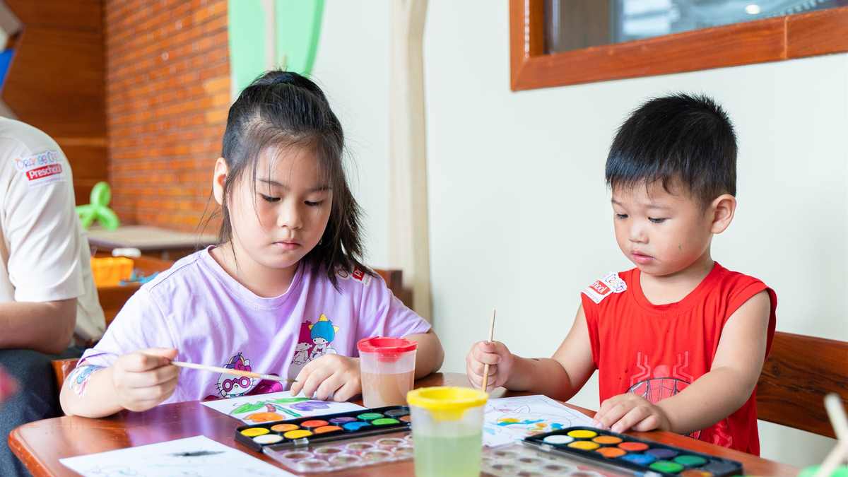 Children painting together at a shared table at Orange Crest Preschool