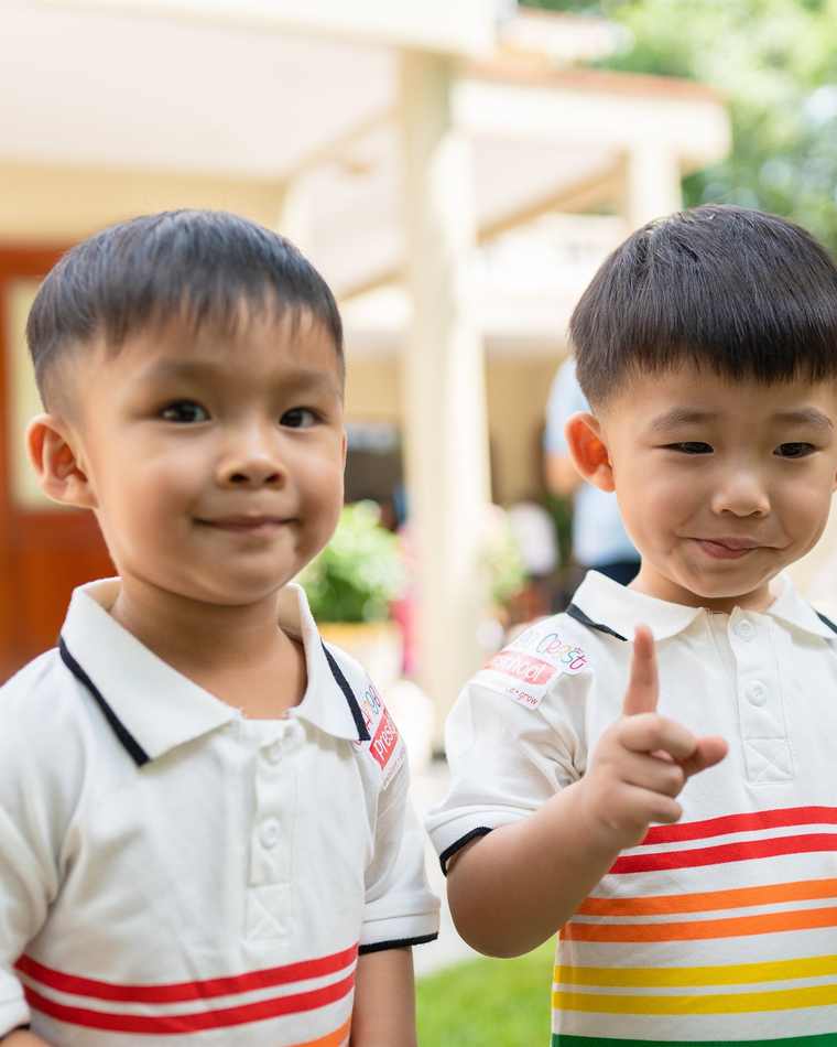 Two children smiling together in the garden at Orange Crest Preschool