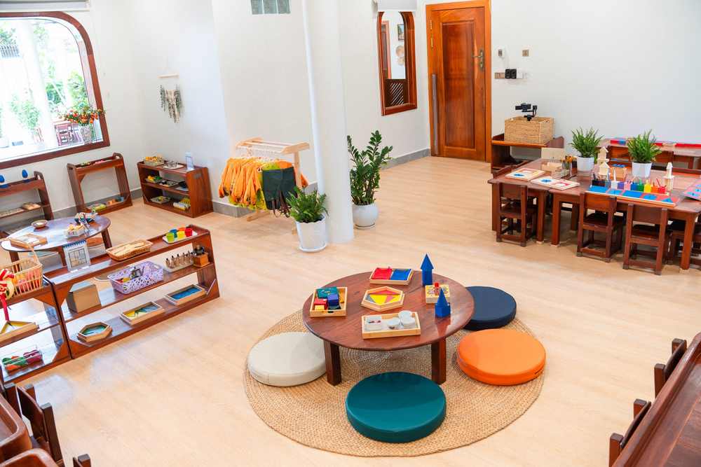 A low round table on a rug, ringed by floor cushions, in a classroom at Orange Crest Preschool