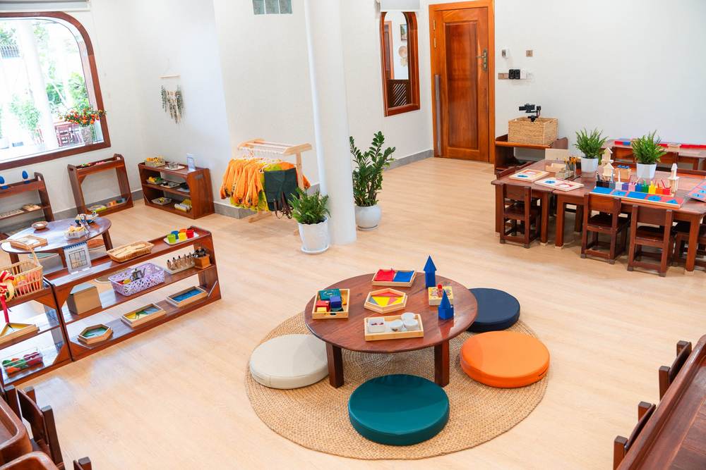 A low round table on a rug, ringed by floor cushions, in a classroom at Orange Crest Preschool