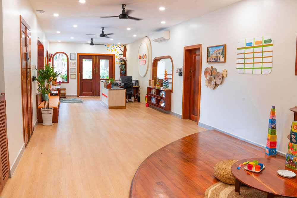 The corridor at Orange Crest Preschool, with a timber floor leading past a mirror and plants towards the classrooms