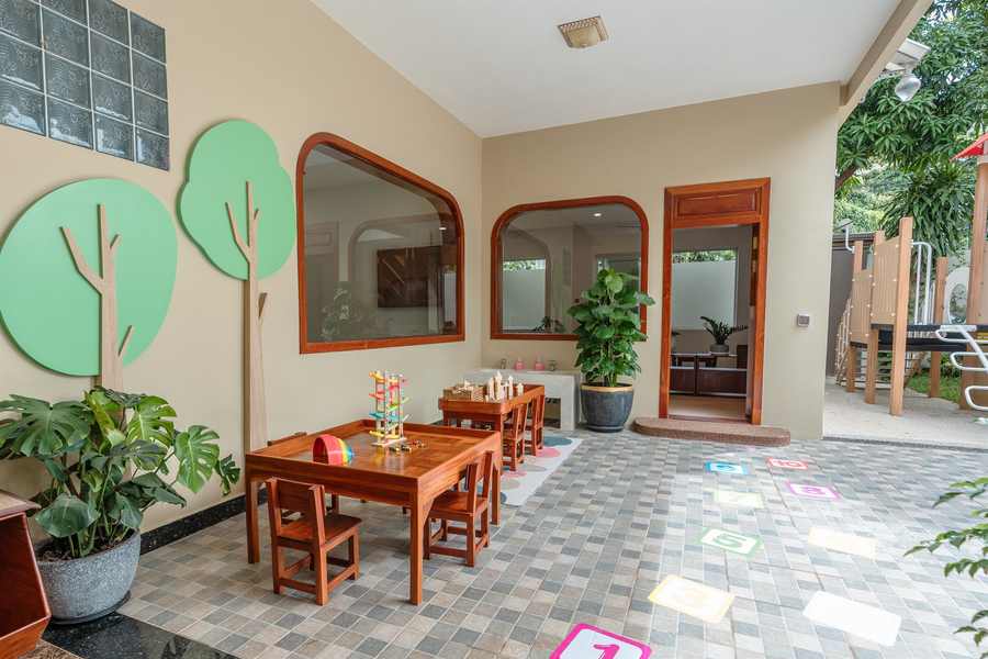 A covered walkway at Orange Crest Preschool painted with tree murals