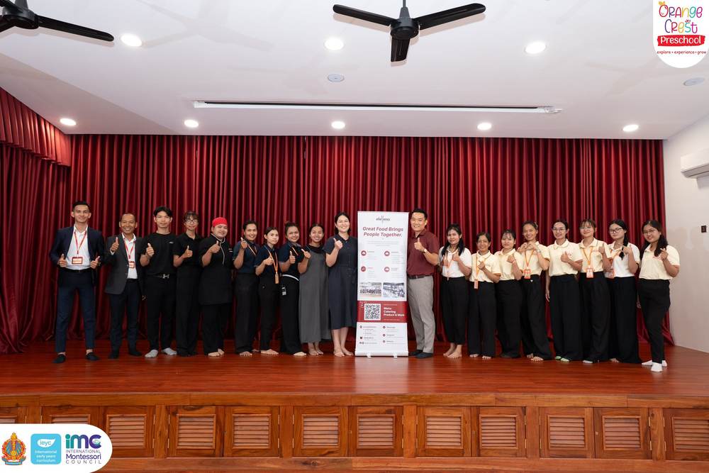 The Orange Crest teaching team and the Eleven One Kitchen team standing together on the hall stage