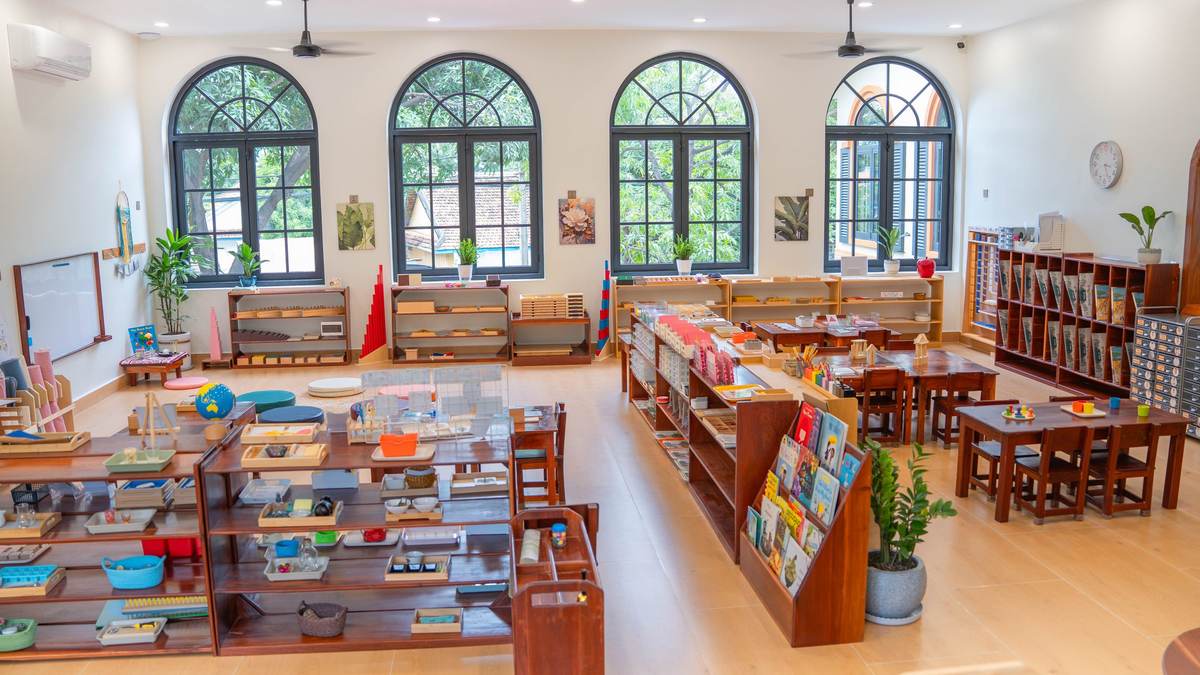 The Montessori classroom at Orange Crest Preschool in Toul Kork, Phnom Penh: arched windows, low wooden shelves of Montessori materials and child-sized tables