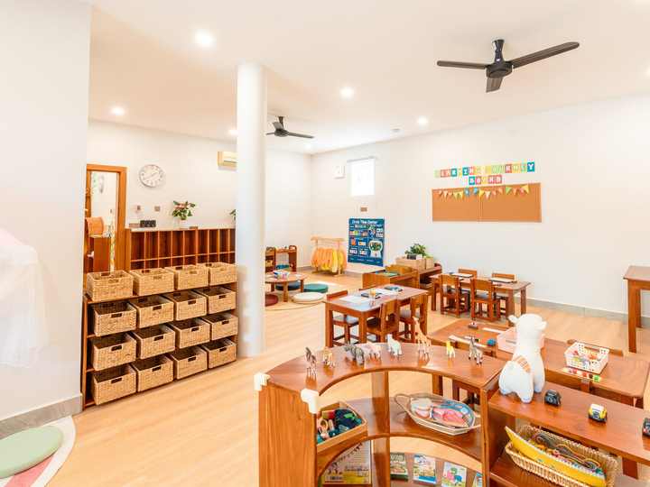 Montessori practical life materials arranged in order on low open wooden shelving
