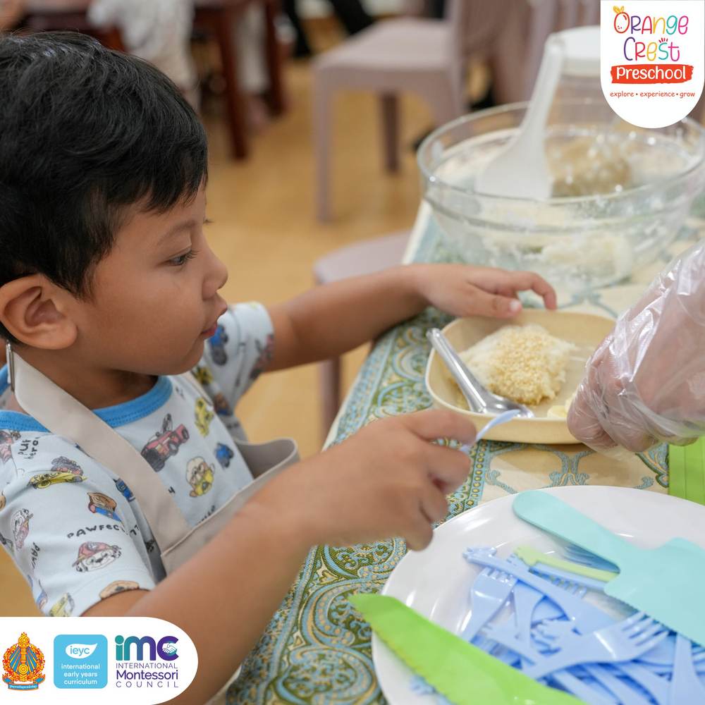 A child spooning rice from a bowl onto the parcel in front of them