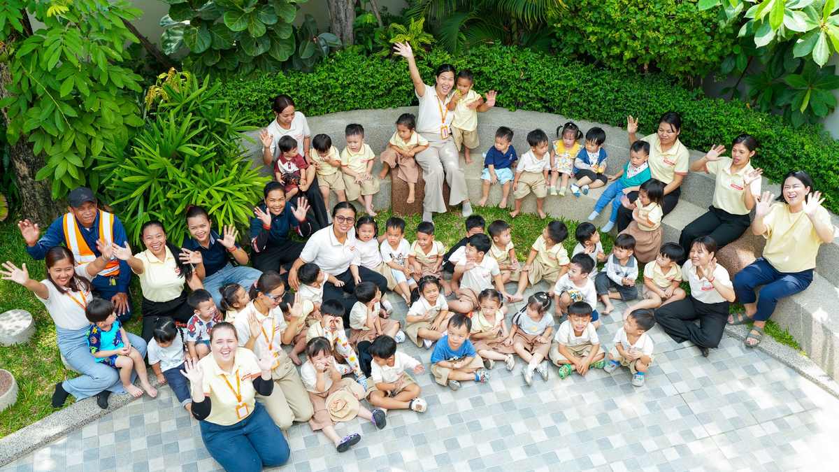 The children and staff of Orange Crest Preschool sitting together in the garden