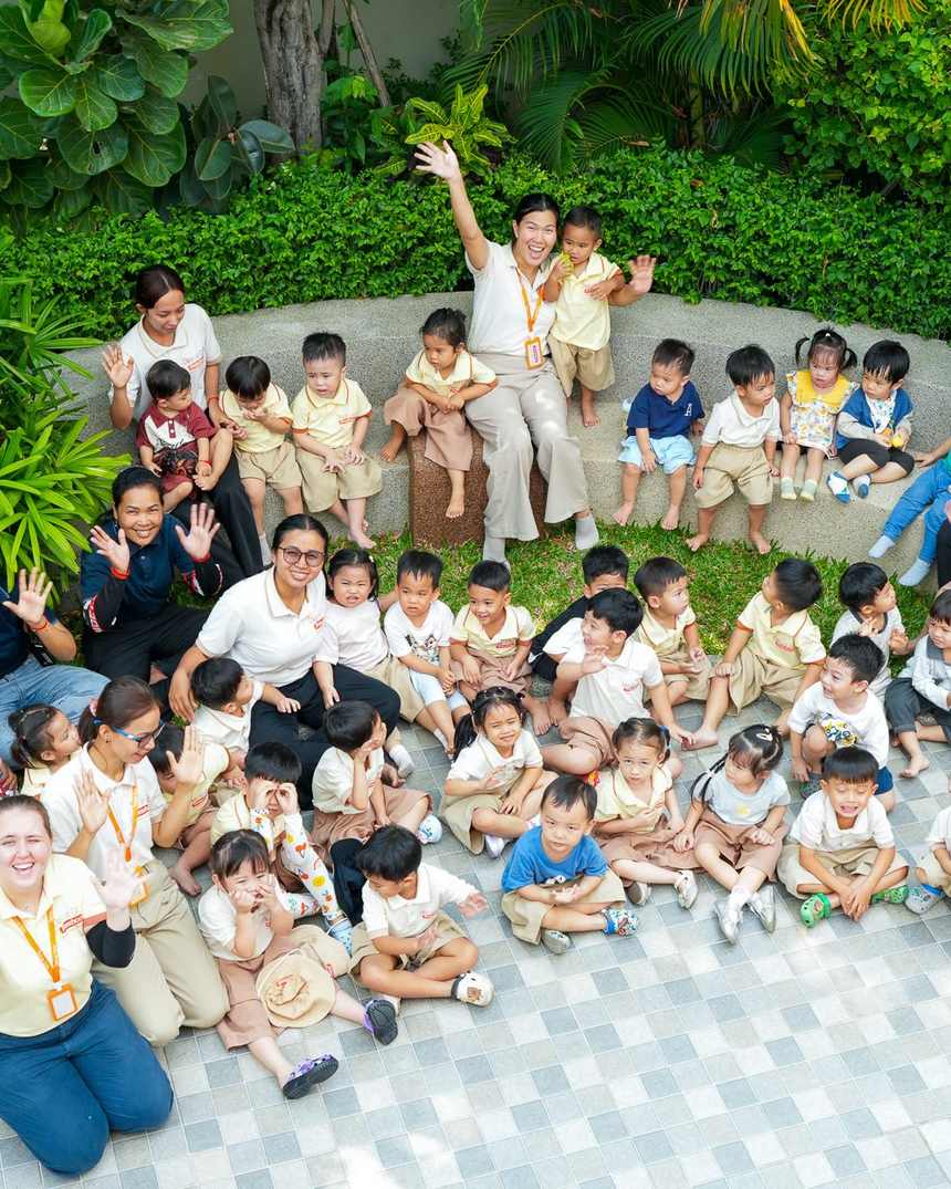 The children and staff of Orange Crest Preschool sitting together in the garden